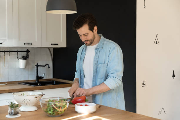 istock Handsome happy young man cooking alone in kitchen. 1320551805