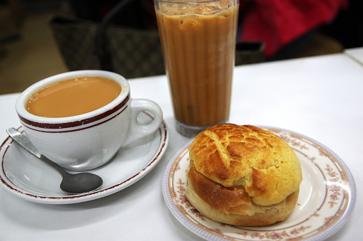 Popular Cantonese breakfast or tea time favorite snack consisting of pineapple bun and Hong Kong style milk tea.