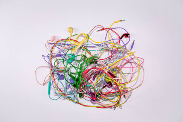 istock Tangled multi colored earphones headsets laying on flat white surface background 1320559851