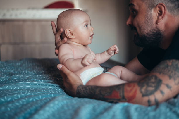 istock Tattooed bearded father playing with his son 1320560655