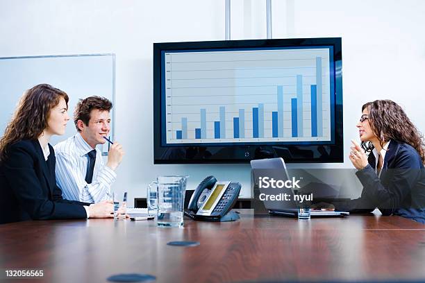 Seated Businesspeople Discussing In Meeting Room Stock Photo - Download Image Now - Advice, Chart, Computer