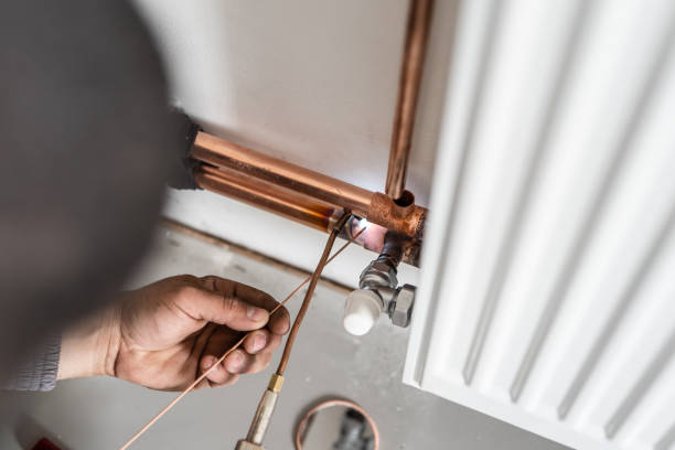 istock Unknown industrial worker plumber with central heating copper pipes welding using gas torch or blowtorch on the wall in house building or apartment - real people at work copy space 1320565937