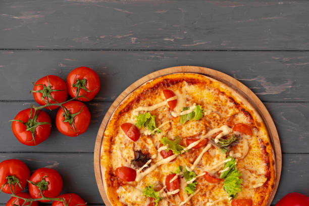 istock Delicious pizza on gray wooden background top view 1320572115
