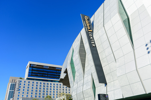 Golden 1 Center sign on the modern facade of indoor arena. Kimpton Sawyer Hotel exterior. - Sacramento, California, USA - 2021