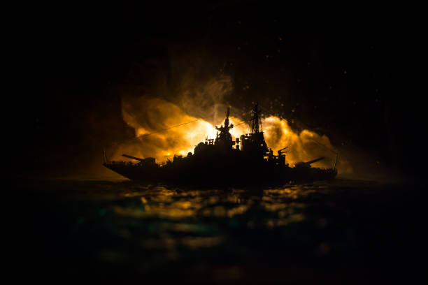 silhuetas de uma multidão em pé em navio de guerra militar borrado em fundo nebuloso. foco seletivo. - sea battle - fotografias e filmes do acervo
