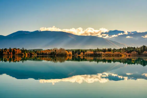 The snow capped Southern Alp peaks  reflected on on the still calm water of the rowing course at Lake Ruataniwha in NZ South Island
