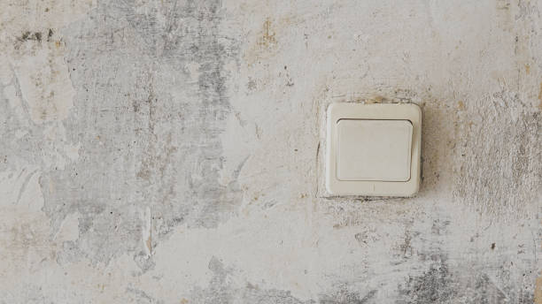 istock Old electric switch on concrete wall with peeling paint 1320590969