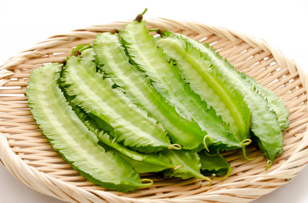 istock Fresh Winged beans on a bamboo sieve on a white background 1320591227