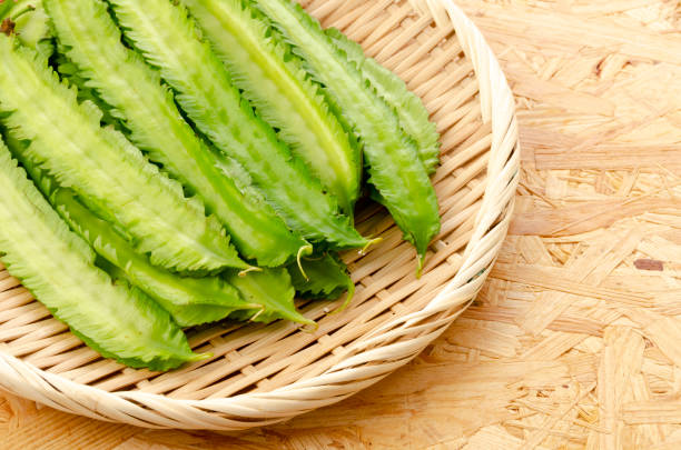 istock Fresh Winged beans on a bamboo sieve on a plywood Board background 1320591289