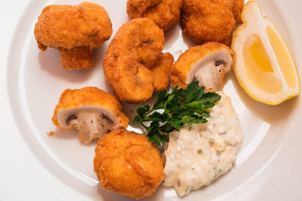 Breaded Fried Button Mushrooms with Tartar Sauce and a Lemon Wedge, Viennese Style Baked Champignons or Gebackene Schwammerl Close Up
