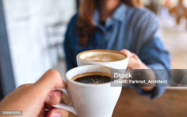 A Woman And A Man Clinking Coffee Cups Together In Cafe Stock Photo - Download Image Now