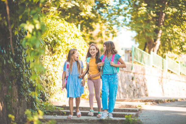 istock Three little girls going to school. 1320595557