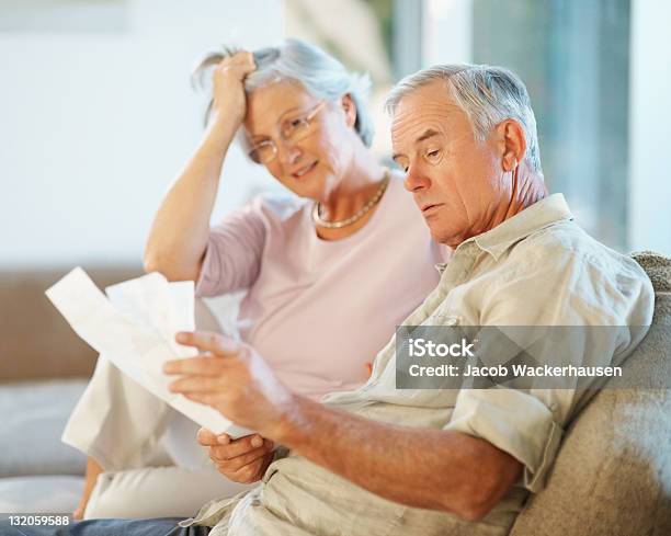 Senior Man And Woman Going Through Payment Bills Stock Photo - Download Image Now - Confusion, Senior Adult, Financial Bill