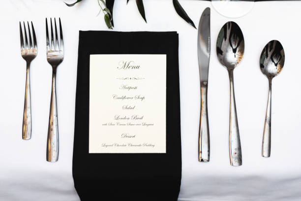 istock Personal place setting for formal black and white social dinner, forks, spoons, knife, and menu 1320601222