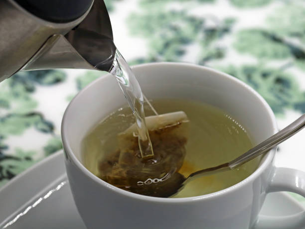 istock hot water flows from the water heater into a white mug with a tea bag, close up 1320602063