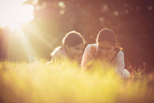 istock Mother and daughter spending time in nature. Lying on grass. 1320605039