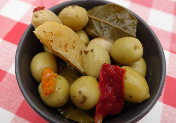 green olives in brine and aromatics lemon confit red pepper bay leaf  mediterranean culture aperitif - bay leaf healthy eating food and drink red imagens e fotografias de stock