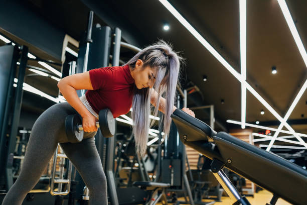 istock Dedicate female athlete, doing the biceps workout with weights, so she can prepare her body for future competition 1320613733
