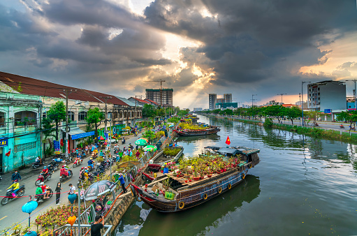 Ho Chi Minh City, Vietnam - February 9, 2021: Flowers boat at flower market along canal wharf. This place Farmers sell apricot blossom and other flowers on Lunar New Year in Ho Chi Minh city, Vietnam