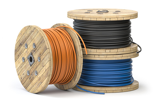 Cable eléctrico de alambre de diferentes colores sobre bobina de madera o carrete aislado sobre fondo blanco. photo