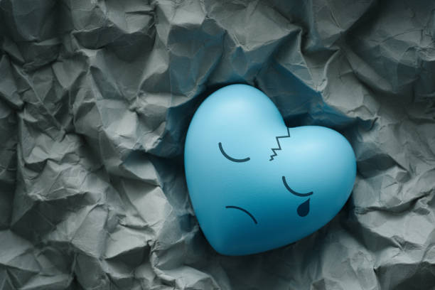 Blue cracked heart on scrunched paper.