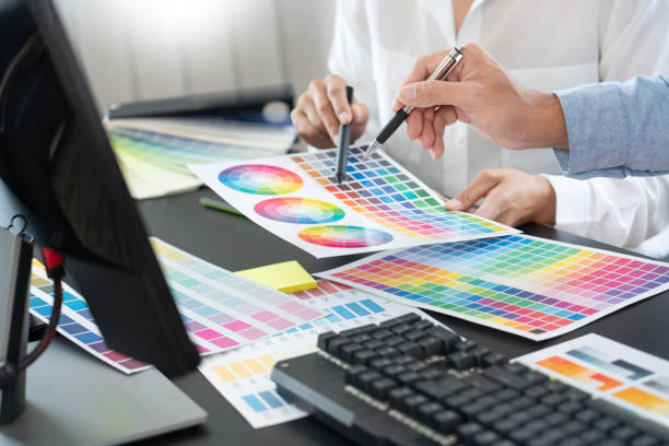 istock Graphic designer or creative working together coloring using graphics tablet and a stylus at desk with colleague 1320618095