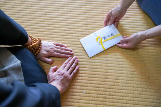 It is written in kanji as "Fuse", which means to express gratitude to the monk. There is money in the envelope