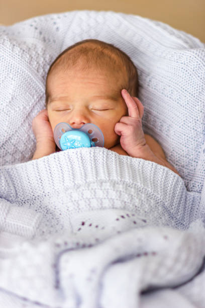 istock Sleeping newborn baby boy with pacifier. Babyface close-up. 1320620774