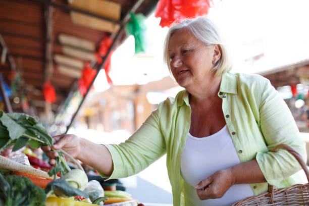 istock Senior woman buying fresh vegetables. 1320621810