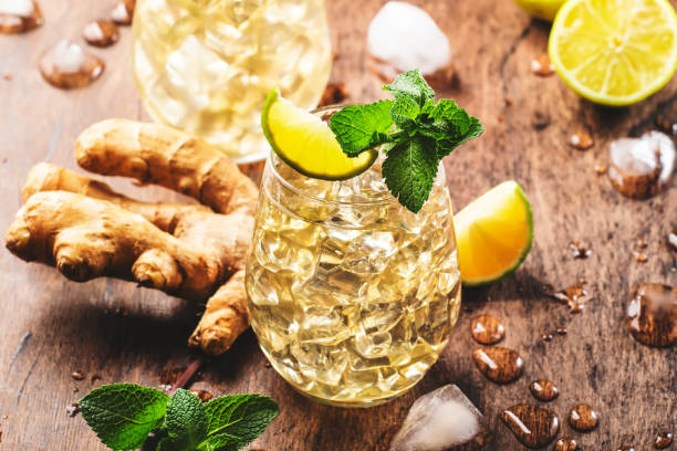 ginger ale cocktail alcolico con birra, lime, limone e foglie di menta in glaass su tavolo di legno - ginger tea root hot drink foto e immagini stock