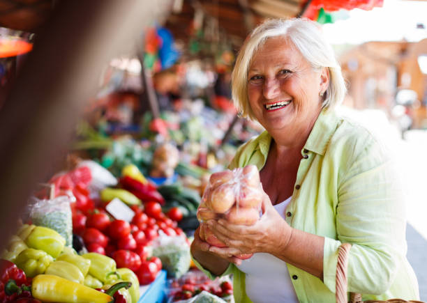 istock Senior woman buying potatoes. 1320623941