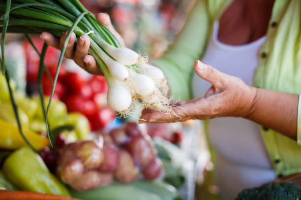 Buying leeks on farmer's market. Close-up.