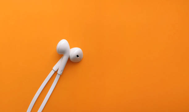 istock White wired headphones on an orange background with copy space 1320624949