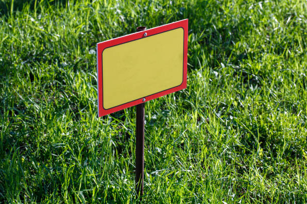 istock blank yellow sign mockup on green lawn background - close-up with selective focus 1320626768