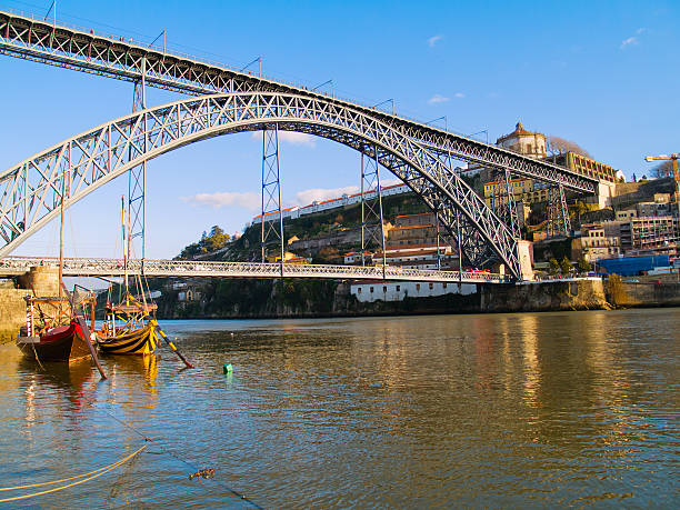 Porto, Portugal - May 2, 2019: Picturesque panoramic view of metal Luis I bridge, Douro river with boat and colorful old houses in the ancient town Porto, Portugal.
