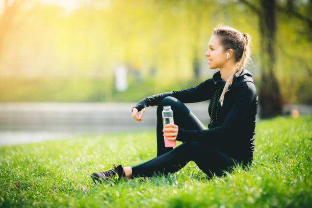 istock Attractive girl using her phone, wireless headphone while running in the park 1320627437