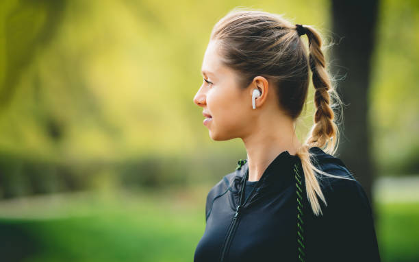 istock Attractive girl using her phone, wireless headphone while running in the park 1320627529