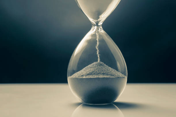 istock Hourglass on a dark background. Time is money. Business solutions in time. 1320630767