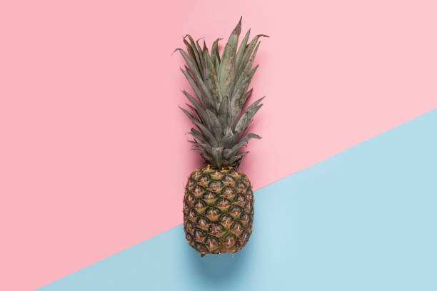 istock whole pineapple on a pink and blue background. Top view, flat lay 1320632704