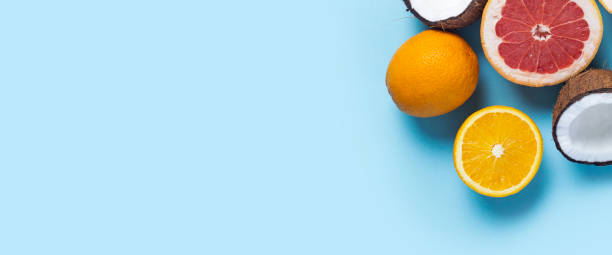 istock exotic fruits on a blue background. Coconut, orange, grapefruit. Top view, flat lay. Banner 1320633694