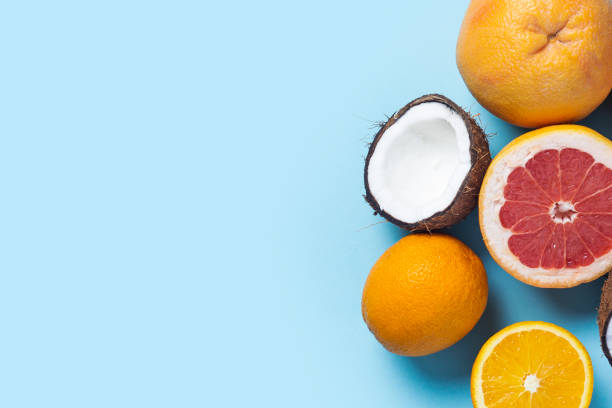 istock exotic fruits on a blue-pink background. Coconut, orange, grapefruit. Top view, flat lay 1320633736