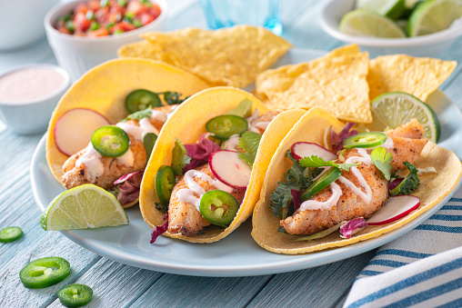 Delicious traditional spicy fish tacos with jalapeno, cilantro, cabbage and radish,