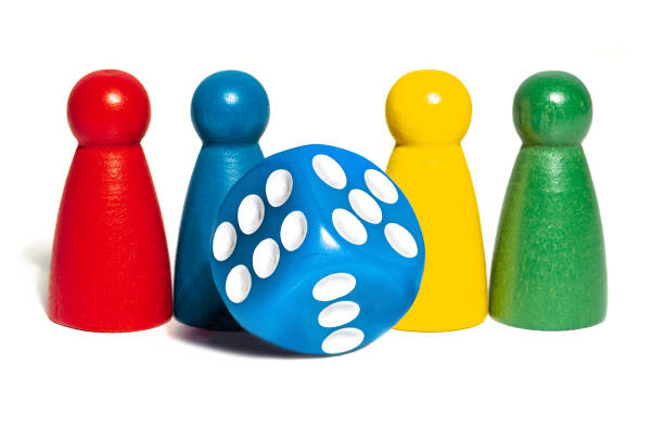 istock Four board game pieces and blue dice over a plain 1320635999