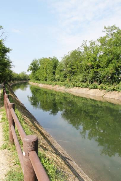 istock Water channel surrounded by nature, the wooden balustrade runs 1320636021
