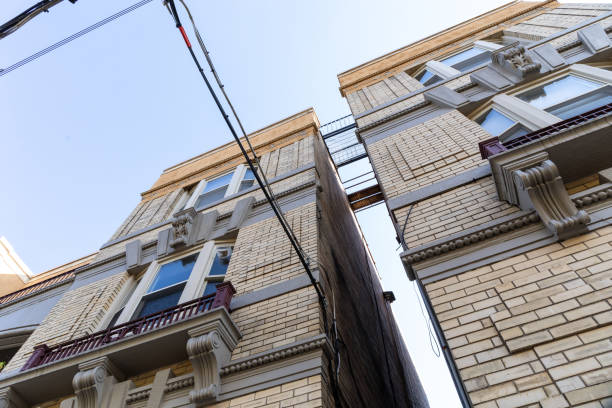 Two tan brick apartment buildings with rooftop walkways between them, urban landscape, horizontal aspect