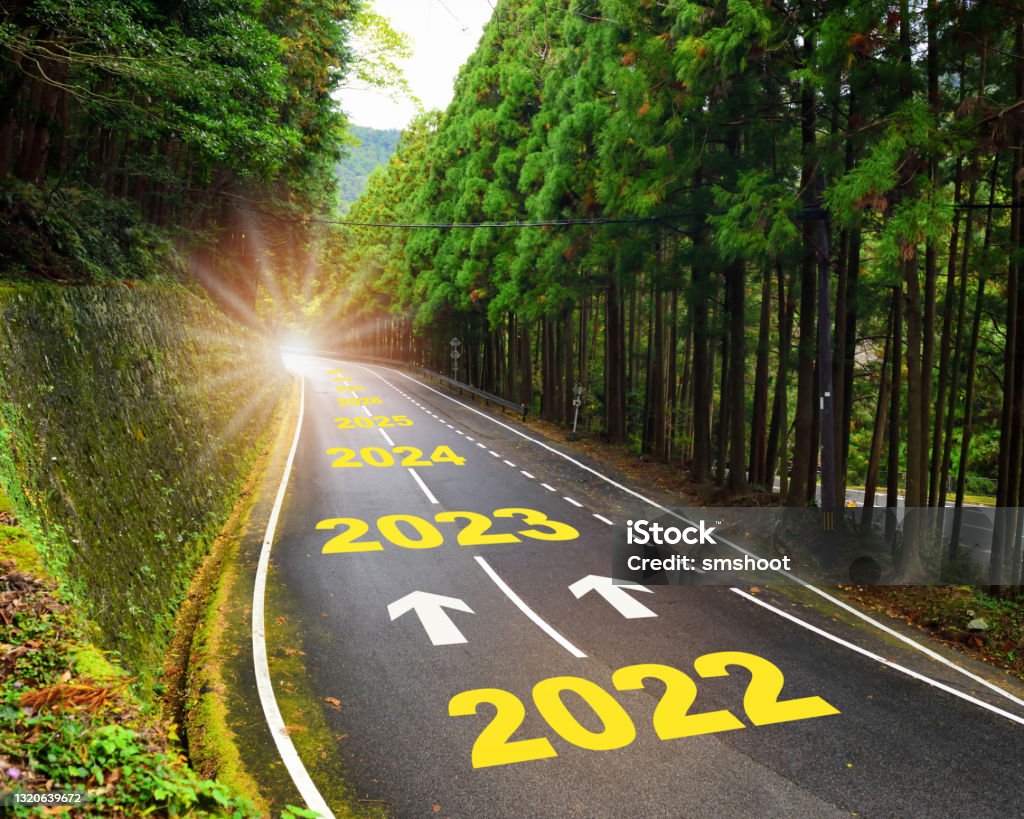 Future ahead from 2022 to 2030 with arrow on highway road and white marking lines in the forest Business recovery concept and challenge to success idea 2022 Stock Photo