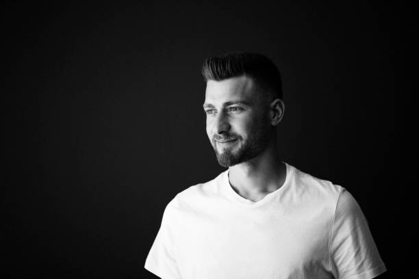 Cropped portrait of a young man against a black background
