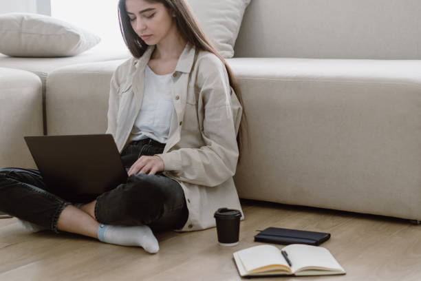 istock Young woman sitting on floor with laptop 1320641958