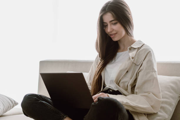istock Young woman using laptop sitting at home 1320641968