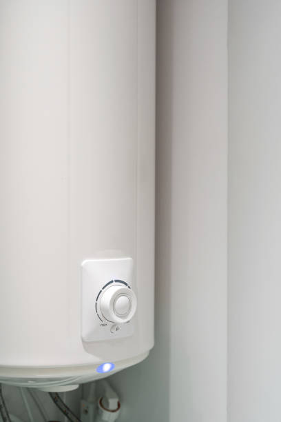 istock Electric boiler hanging on wall in white bathroom 1320642115